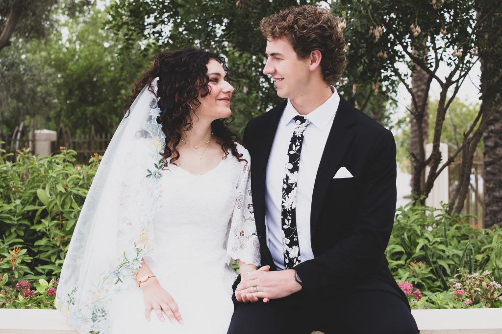 Bride and groom sitting on a bench and looking at each other